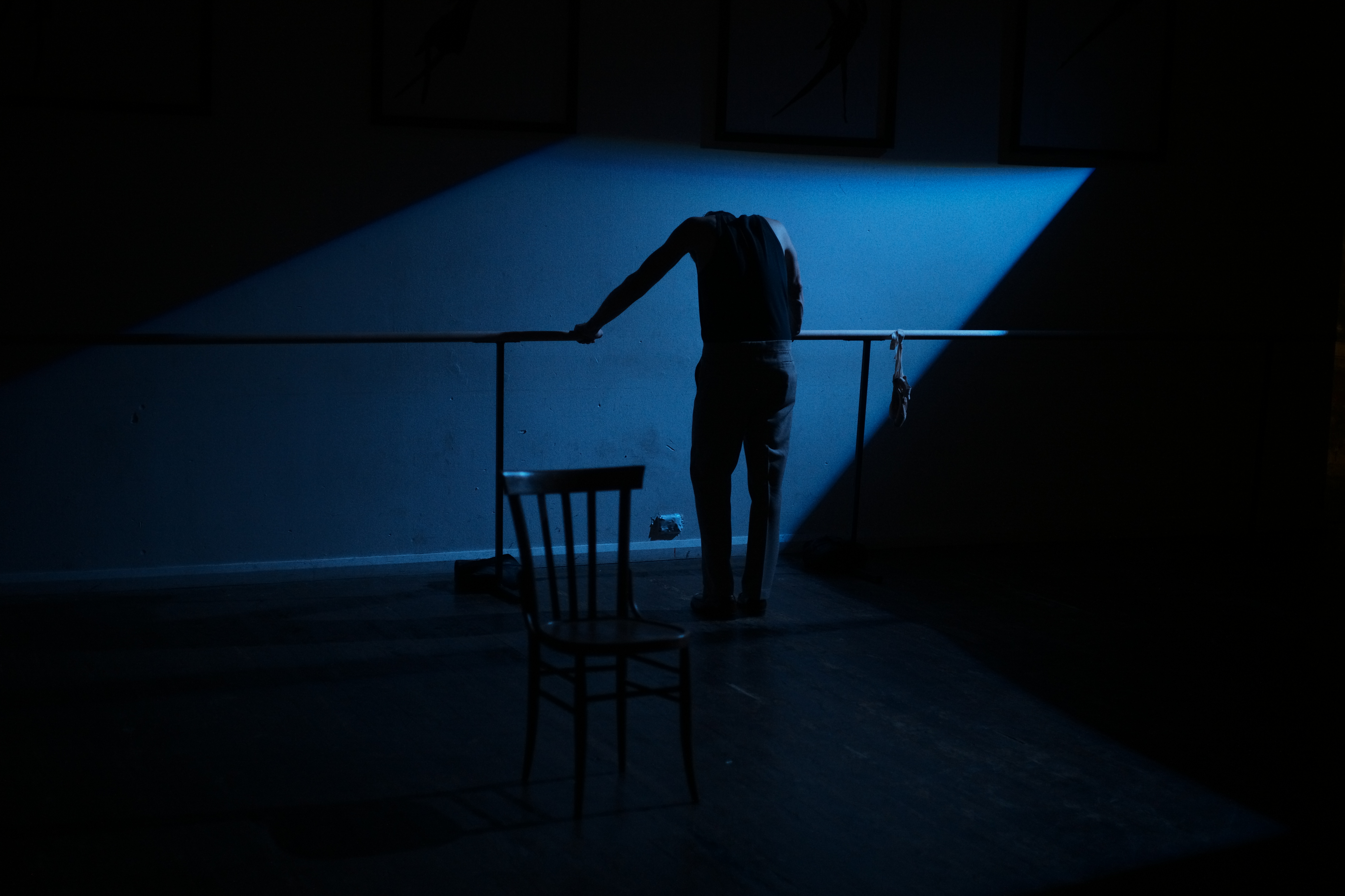 Mark Diaco alone on a blue-lit stage